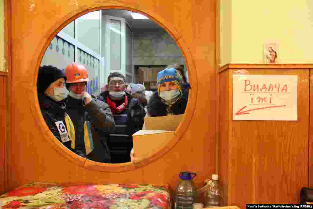 Volunteers wait outside the kitchen to carry food to Independence Square.