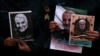 Iranian Guards hold a picture of the late Iranian Major-General Qassem Soleimani and an Iraqi militia leader, during a protest against their targeted killing. January 3, 2019