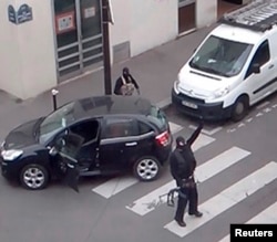 Atacatorii de la Charlie Hebdo, ieșind din biroul în care au ucis 12 persoane pe 7 ianuarie 2015.