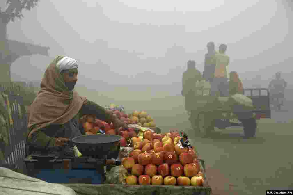 Një shitës frutash në një ditë me mjegull në Lahore, Pakistan. Mjegulla e dendur ka përfshirë shumë pjesë të Pakistanit, duke shkaktuar aksidente në autostradë dhe probleme me frymëmarrje dhe duke detyruar shumë banorë të qëndrojnë në shtëpi, thanë zyrtarët.