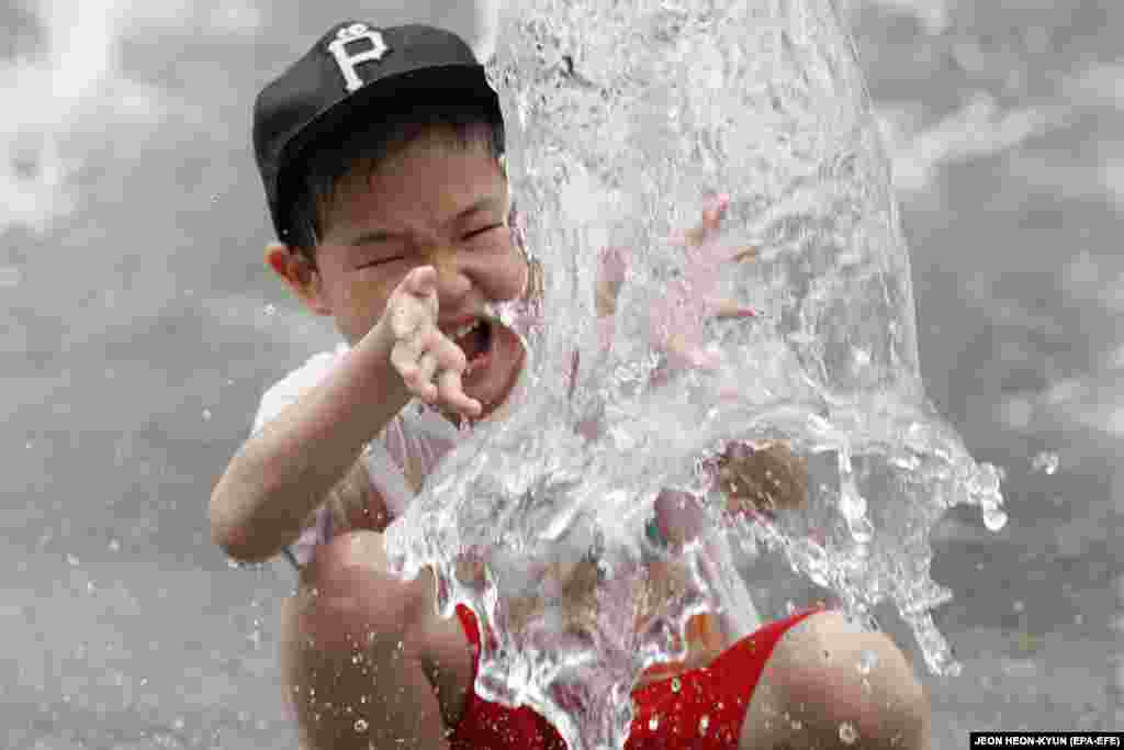 A South Korean child cools off in a fountain in Gwanghwamun Square in Seoul. A heat wave continues to affect many areas of South Korea, with temperatures rising to a high of 38 degrees Celsius. (EPA-EFE/Jeon Heon-Kyun)