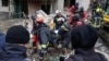 Rescuers carry the body of a person found under the debris of an apartment building that was hit by a Russian air strike in Kharkiv on October 31.