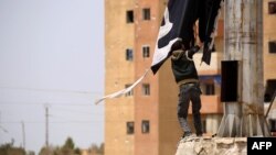 İŞİD-in bayrağını cırıb atır.