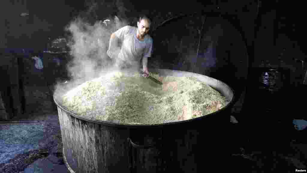 A worker in Syria prepares food for distribution to the residents and those displaced in the city of Raqqa. (Reuters/Nour Fourat)