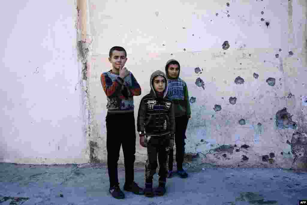 Boys watch as demining experts from the Iraqi Army search for booby-trapped buildings in eastern Mosul during an ongoing military operation against Islamic State militants. (AFP/Dimitar Dilkoff)