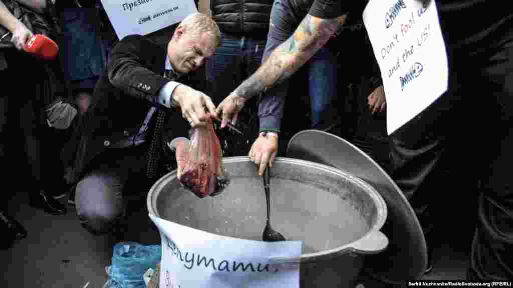 Віталій Шабунін кидає до юшки інгредієнти страви, яку готують для депутатів