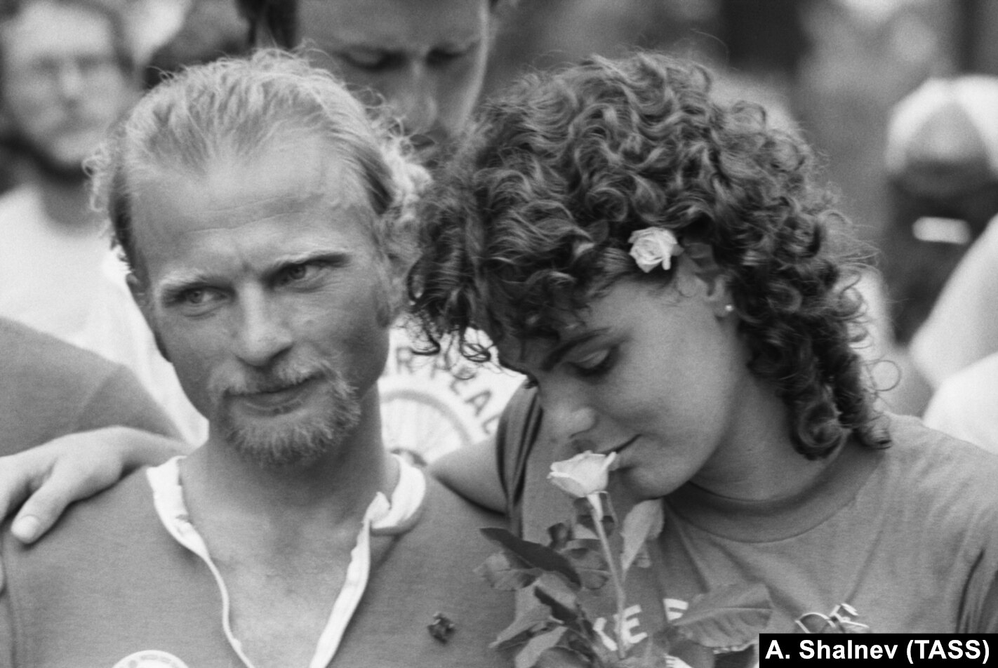 1983 年和平集會的參與者在華盛頓停下來聞聞玫瑰花香。