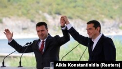 Premierii Alexis Tsipras și Zoran Zaev în momentul semnării acordului istoric în satul Psarades, Prespes, Grecia