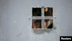 Украинские военнослужащие смотрят из-за ворот своей военной базы, Севастополь, март 2014 года