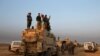 Iraqi Kurdish Peshmerga forces stand on a military vehicle in the town of Bashiqa, east of Mosul, during an operation to attack Islamic State militants in Mosul, on November 7.