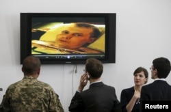 Учасники прес-конференції у Києві дивляться відео з одним із полонених військовослужбовців. 18 травня 2015 року