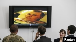 Украинские журналисты и военные перед пресс-конференцией в Генштабе, посвященной задержанию россиян в Луганской области. На экране - фрагмент видео допроса Александра Александрова, одного из задержанных