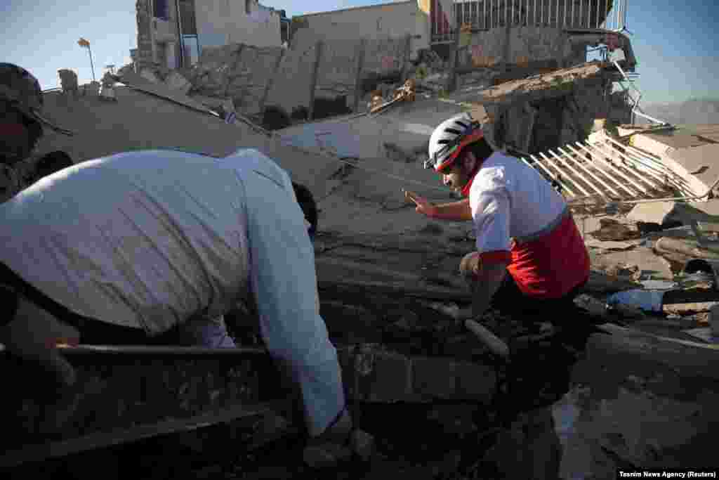 Rescue workers search for victims under the rubble of a collapsed building in Sarpol-e Zahab.