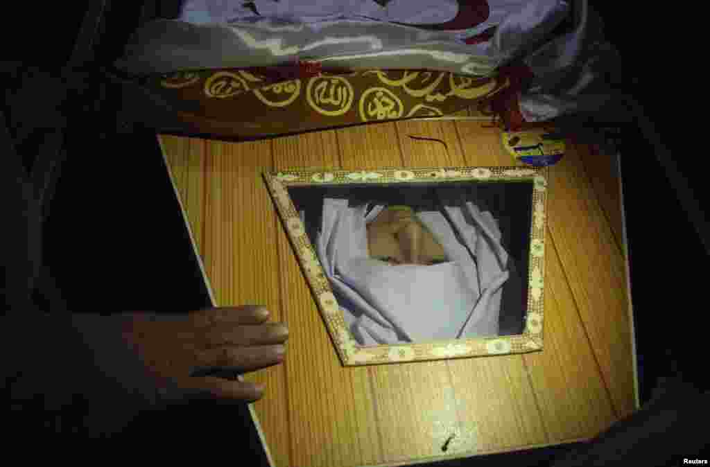 A man touches the coffin of one of the 132 students killed during an attack by Taliban gunmen on the Army Public School in Peshawar, Pakistan. (Reuters/Khuram Parvez)