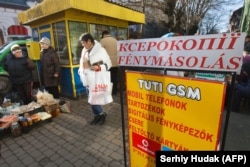 Місцеві жителі біля рекламного плаката угорською мовою в Берегові, 15 листопада 2017 року