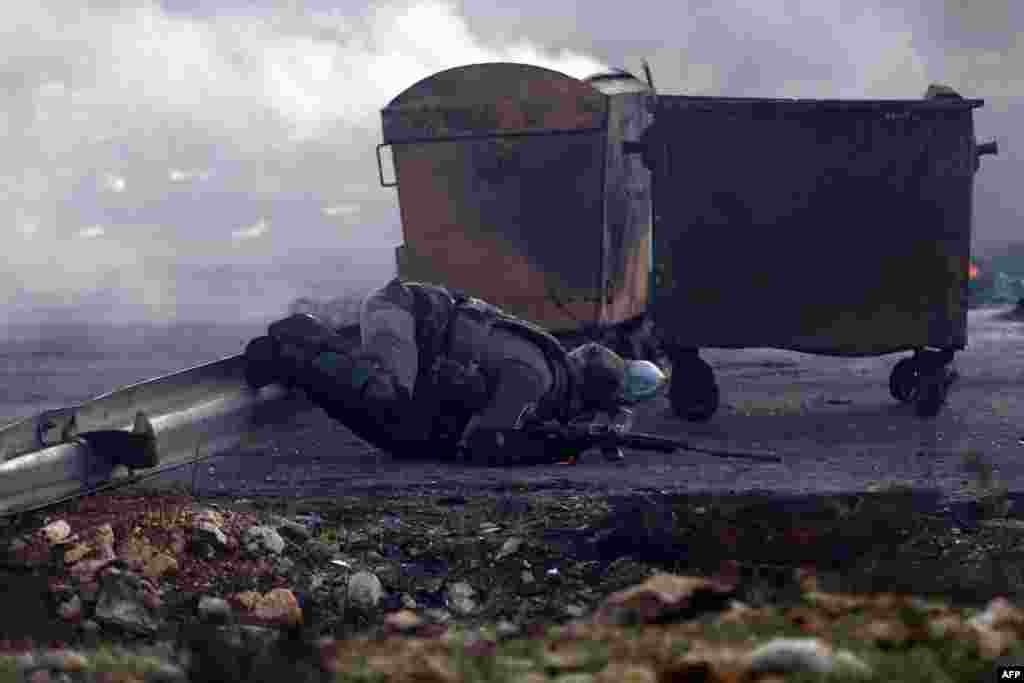 An Israeli border guard trips on a road barrier during clashes with Palestinian protestors on the outskirts of Ramallah in the Israeli-occupied West Bank on November 11. (AFP/Abbas Momani)