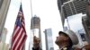 New York Fire Department Battalion Commander Tom Currao raises a flag outside the World Trade Center construction site at the 9/11 Memorial Visitors Center in New York.