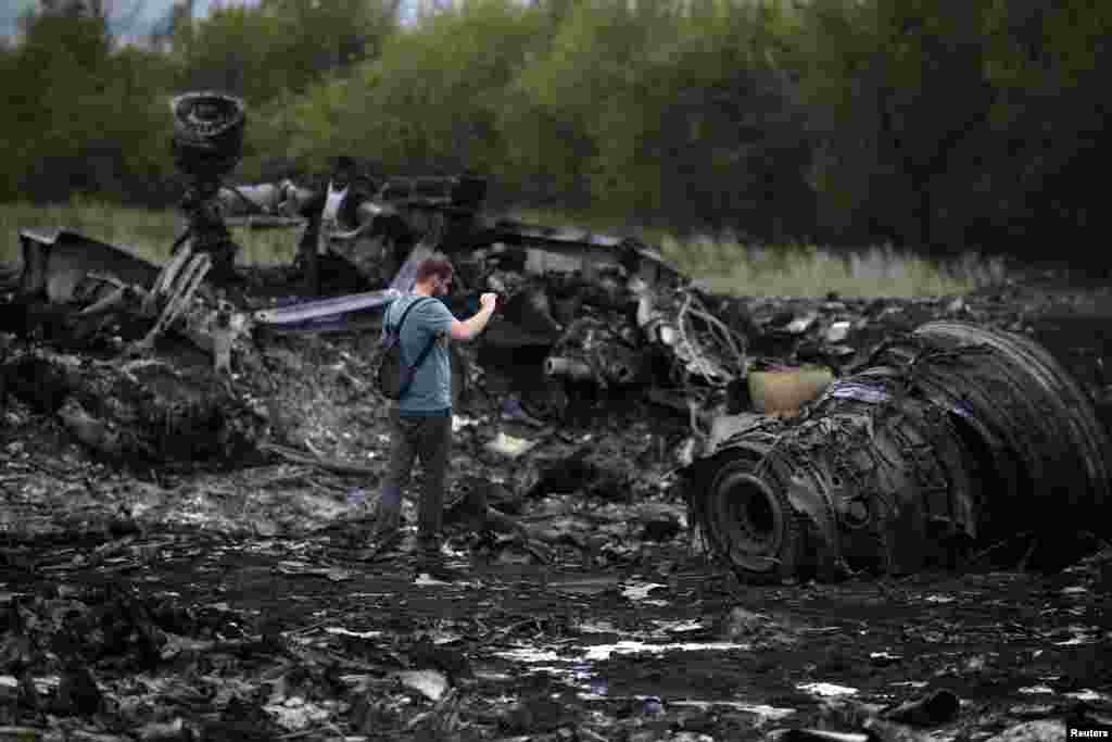 A journalist takes photographs at a crash site on July 18.