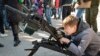 Ребенок со станковым гранатометом АГС 17 "Пламя" в руках на выставке сирийского оружия. 
