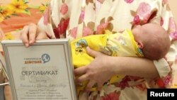 Марина Ніколаєва тримає її новонародженого сина Петра, ​​який, як вважають, став семимільярдним жителем Землі, Калінінград, 31 жовтня 2011 року