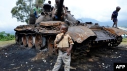 Дети в Демократической Республике Конго, играющие на сгоревшем танке одной из антиправительственных вооруженных группировок