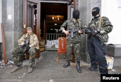 Вооруженные представители пророссийских сил возле здания областной администрации в Луганске, 29 апреля 2014 года. Фото: Reuters