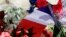 A bouquet of flowers and a French flag are seen as people pay tribute near the scene of the attack in Nice.