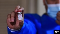 A nurse holds a vial of the AstraZeneca COVID-19 vial