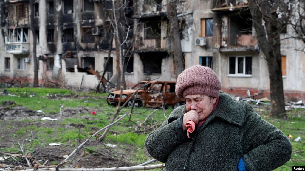 A local resident cries in front of a destroyed apartment building in Mariupol on April 19. 