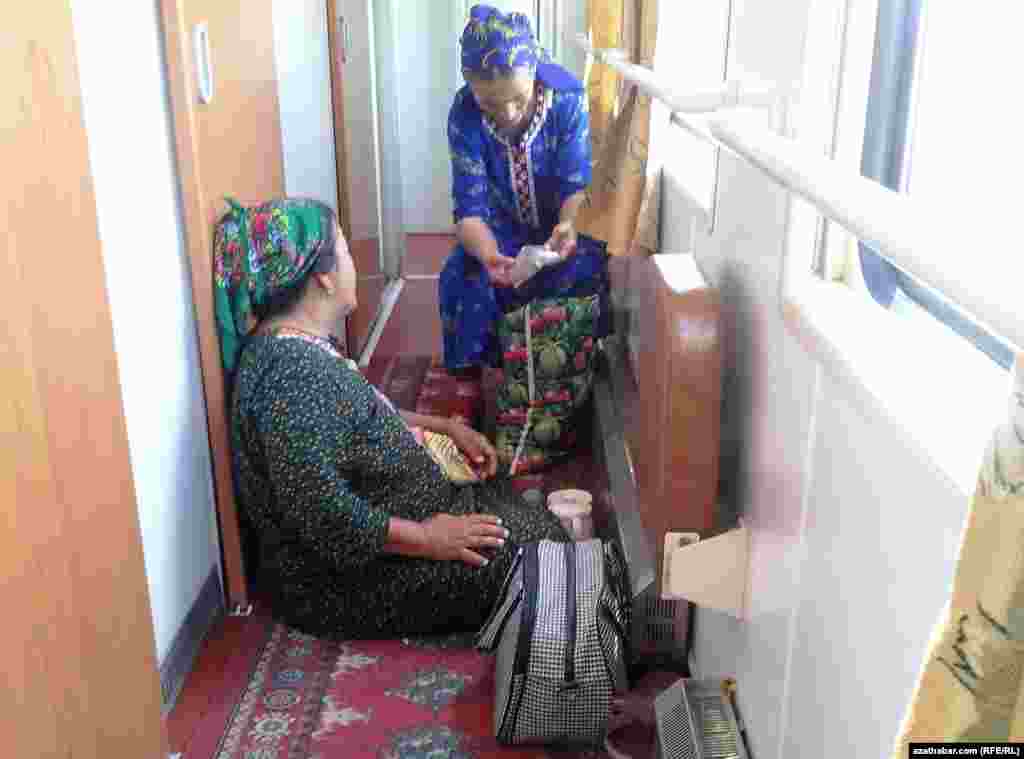 Otlynyň içindäki koridorda oturyp, gürrüň edip barýan aýallar