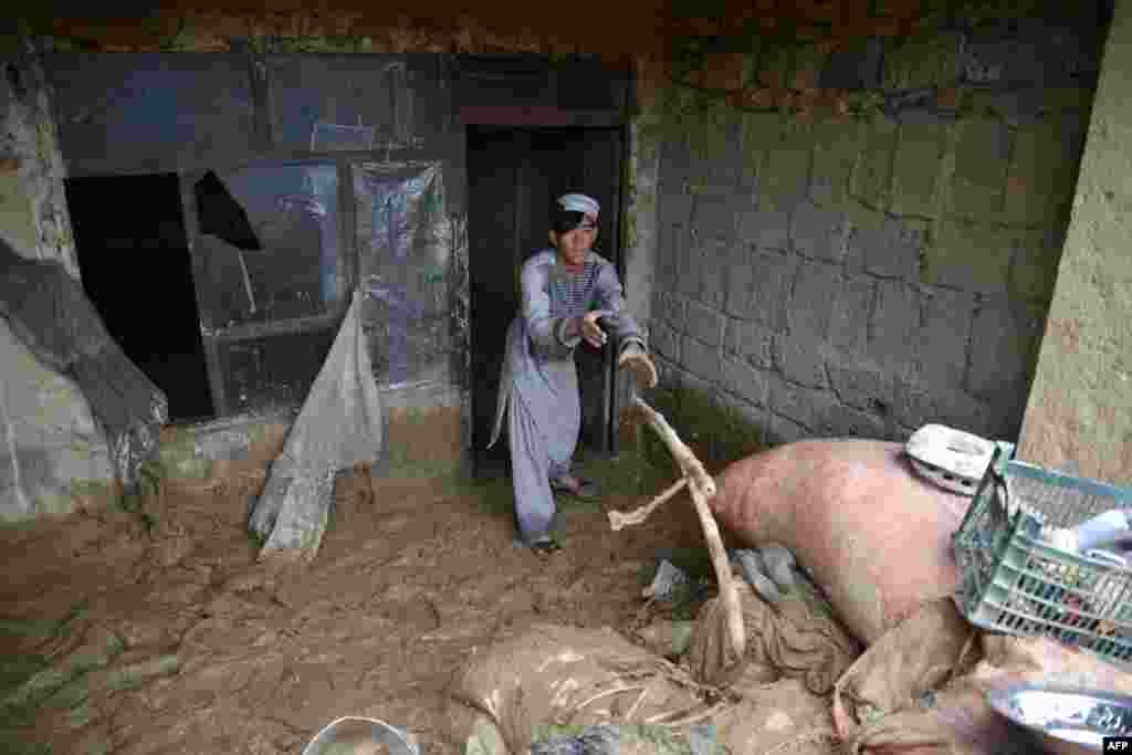 A man in Kandahar removes debris from his home following heavy rains and flash flooding. Afghanistan has been parched by an unusually dry winter that desiccated the earth, exacerbating flash flooding caused by spring downpours in multiple provinces.