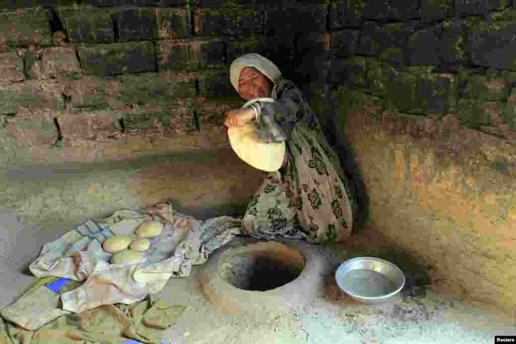 An Afghan woman bakes bread at her house outside Jalalabad. (Reuters/Parwiz)