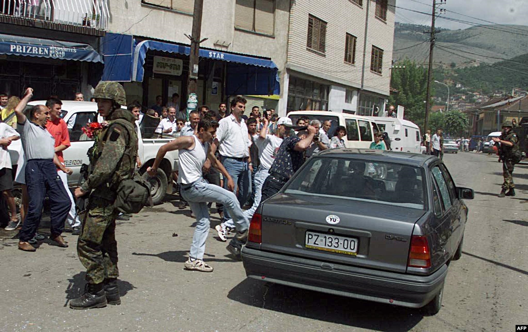 Banorë të zemëruar kosovarë hedhin gurë dhe godasin me shqelma një makinë të banorëve serbë që po largoheshin nga Prizreni, më 13 qershor 1999.