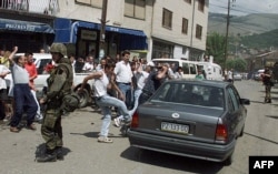 Banorë të zemëruar kosovarë hedhin gurë dhe godasin me shqelma një makinë të banorëve serbë që po largoheshin nga Prizreni, më 13 qershor 1999.