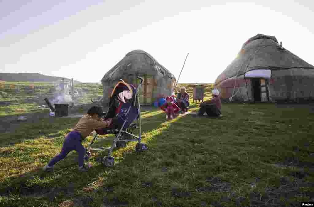 &nbsp;Nurtleu, who is 1 1/2 years old, pushes his stroller in front of his family&#39;s yurts.