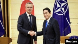 NATO Secretary-General Jens Stoltenberg (left) and Japanese Prime Minister Fumio Kishida shake hands after holding a joint media briefing on January 31 in Tokyo. 