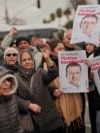 Supporters of Istanbul Mayor Ekrem Imamoglu hold up his pictures outside a police station after his arrest