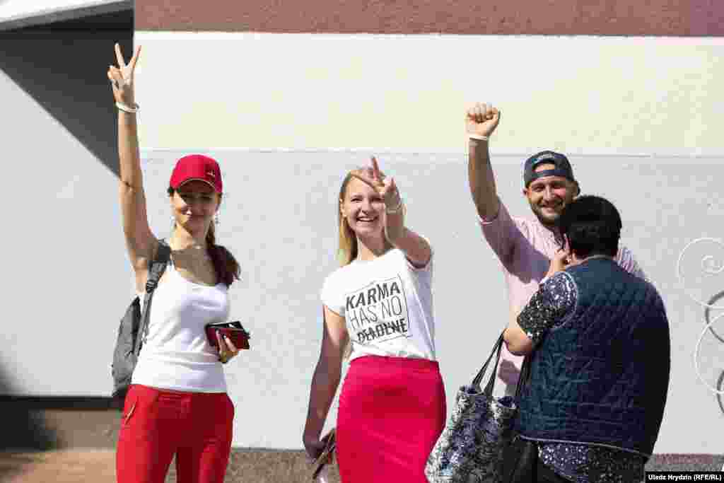 Voters show signs used by the opposition at School 41 in Minsk.