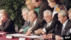 Predsednik Srbije Slobodan Milošević, Predsednik Bosne i Hercegovine Alija Izetbegović i Predsednik Hrvatske Franjo Tuđman u Parizu potpisuju Dejtonski sporazum dok je pored njih tadašnji državni sekretar SAD Voren Kristofer, 14. decembar 1995.
