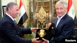 Iraqi Defense Minister Khaled al-Obeidi (left) meets with outgoing U.S. Defense Secretary Chuck Hagel in Baghdad on December 9.