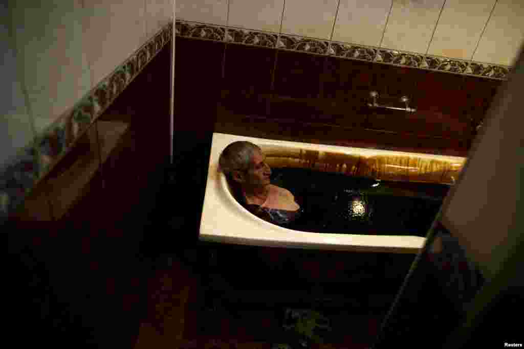 A man lies in a bathtub filled with crude oil during a health therapy session at the Naftalan Health Center in Baku, Azerbaijan. According to Hashim Hashimov, a medical specialist at the center, the oil can heal more than 70 diseases, including neurological diseases, skin conditions, and impotence. Centers like Naftalan attract people coming from Russia, Kazakhstan, and Germany, Hashimov told Reuters. (Reuters/Stoyan Nenov)