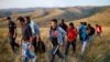 Migrants are escorted by a Serbian border officer near the southern town of Presevo after being caught illegally entering the country from Macedonia.&nbsp;