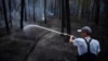 A firefighter extinguishes the remains of a fire in a forest near Yarova in the Holy Mountains National Nature Park in July.