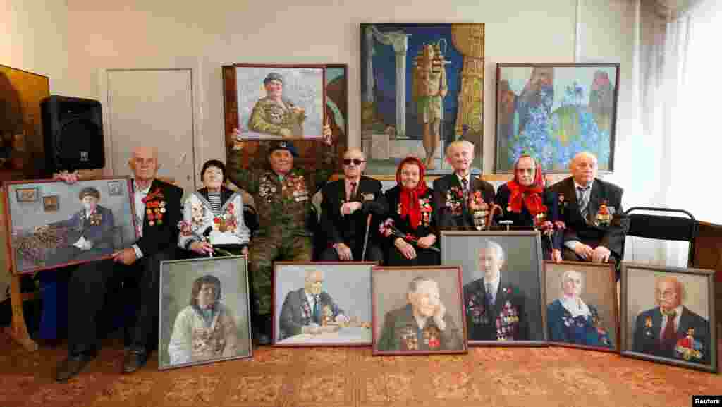 RussiaN World War II veterans pose for a picture with oil portraits of themselves created by students of Krasnoyarsk Art College as presents for the upcoming Victory Day Krasnoyarsk, Siberia, on April 28. (Reuters/Ilya Naymushin)