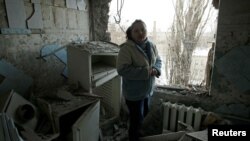 A woman in Donetsk stands amid the debris of her apartment damaged by shelling on February 1.