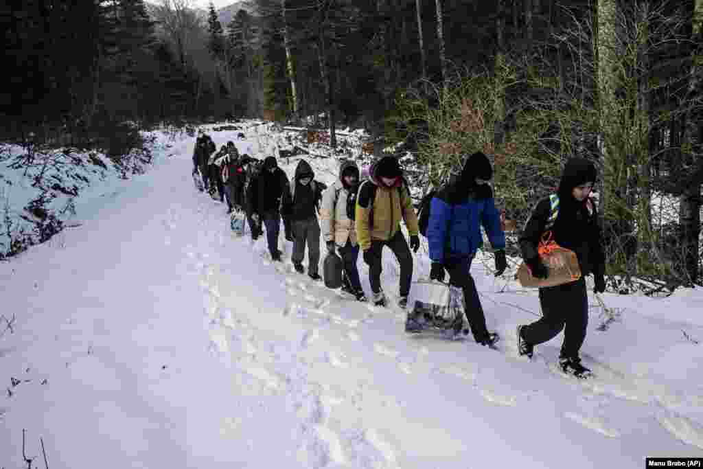 Një grup migrantësh egjiptianë ecin nëpër dëborë në një zonë malore, e cila besohet të jetë e minuar që nga koha e luftës në Bosnje.&nbsp;
