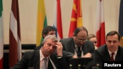 Belarus opposition leader Alyaksandr Milinkevich (L) and Polish Foreign Minister Radoslaw Sikorski share a table at a February 2 Belarus donors' conference in Warsaw.