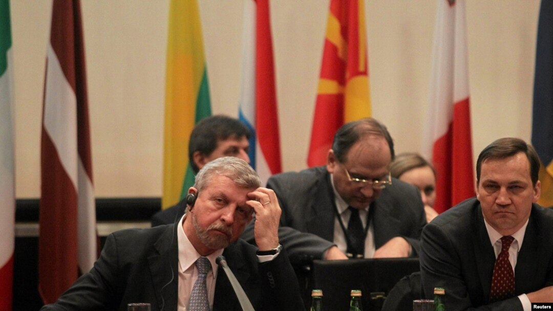 Belarus opposition leader Alyaksandr Milinkevich (L) and Polish Foreign Minister Radoslaw Sikorski share a table at a February 2 Belarus donors' conference in Warsaw.