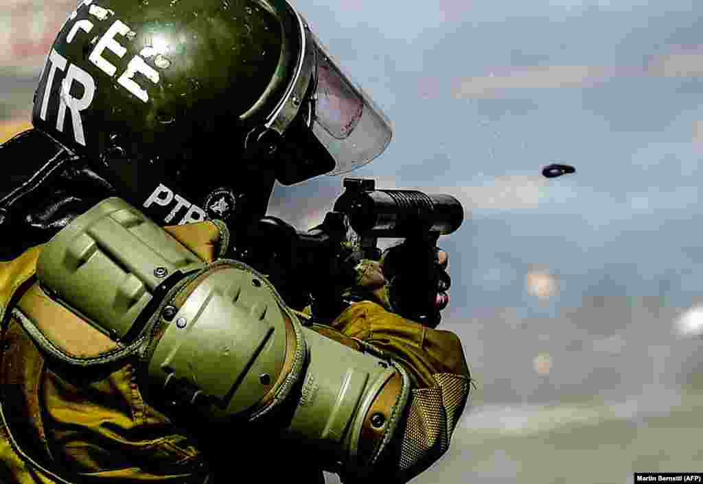 A riot-police officer shoots a tear-gas projectile during a protest in Santiago, Chile, on October 21. (AFP/Martin Bernetti)