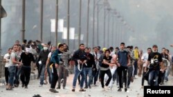 Supporters of ousted Egyptian President Muhammad Morsi throw stones at riot police during clashes in Cairo on November 22.